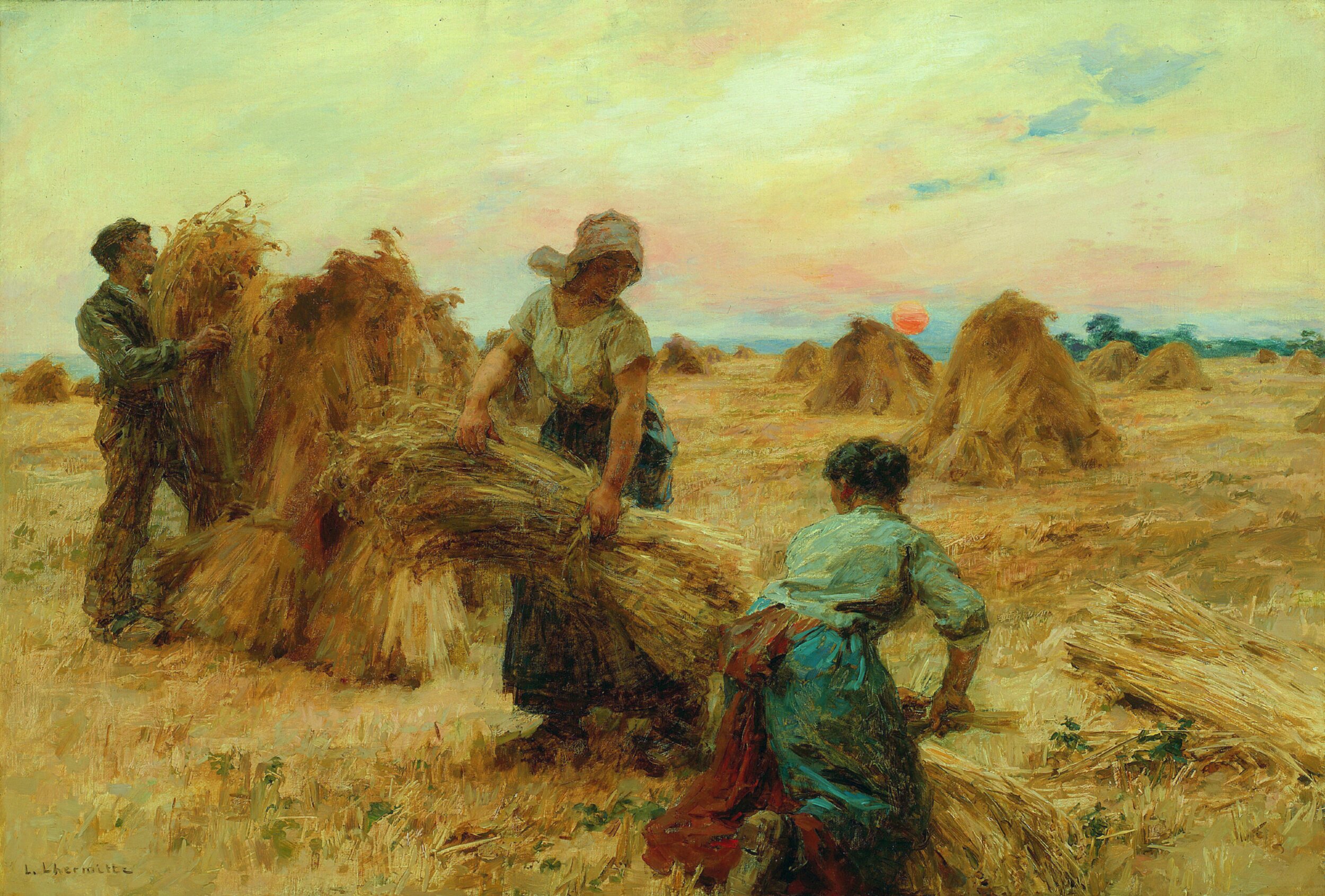 Oil painting of three farm workers binding wheat sheaves into stooks at sunset. A man on the left lifts a bundle of wheat onto a stack, a woman in a white blouse and bonnet carries an armful of cut wheat toward the stack, and a second woman crouches in the foreground gathering stalks. Rows of wheat stooks dot the golden stubble field under a pastel sky with a low orange sun on the horizon. Signed 'L. Lhermitte' in the lower left.