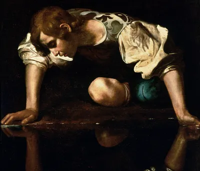 Oil painting by Caravaggio showing Narcissus from Greek mythology. A youth with dark curly hair leans forward on his knees at the water's edge, arms extended to support himself. He wears a loose white shirt with voluminous sleeves and a green sash at his waist. His face is illuminated as he gazes downward at his own reflection in the still, dark water below.