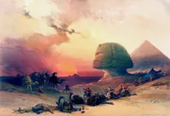 A historical-style painting of a desert landscape at sunset, with the Great Sphinx of Giza and a pyramid in the background. A group of travelers and camels crosses the desert while several people and camels lie or rest in the foreground. The sky is filled with warm pink, orange, and golden clouds, creating a dramatic atmosphere.