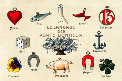 French illustrated card titled 'Le Langage des Porte-Bonheur' (The Language of Good Luck Charms), featuring fourteen labelled lucky symbols arranged around the title: a red heart charm (Amour / Love), a fish (Paix / Peace), a horn (Joie / Joy), a red shoe (Santé / Health), the number 13 in a circle (Longévité / Longevity), a dice (Gain / Gain), a bouquet of daisies and forget-me-nots at centre, an anchor (Espérance / Hope), a pansy flower (Souvenir / Memory), a horseshoe (Veine / Luck), a pig (Prospérité / Prosperity), a red horseshoe magnet (Argent / Money), and a four-leaf clover (Bonheur / Happiness).
