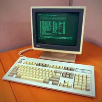 Vintage AT&T terminal and keyboard on a wood desk, displaying a green-phosphor screen with the 'SDF Public Access UNIX System' menu titled 'Hysterical Unix Systems,' listing historical UNIX versions from UNICS (1969) through 2.11 BSD (1986) with a 'Your choice?' prompt below.